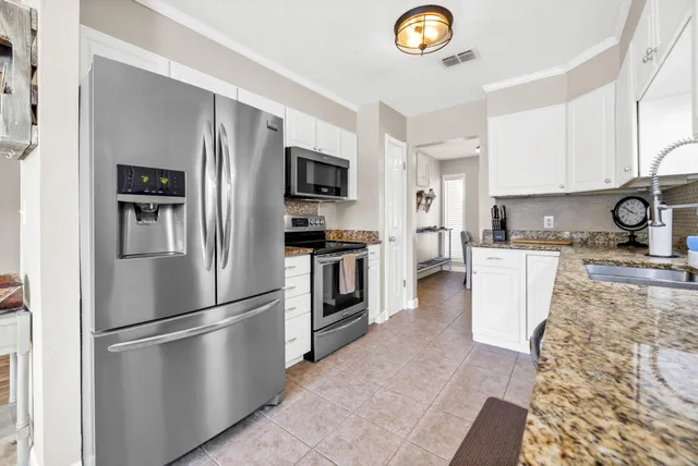 a kitchen with cabinets appliances a sink and a counter top space
