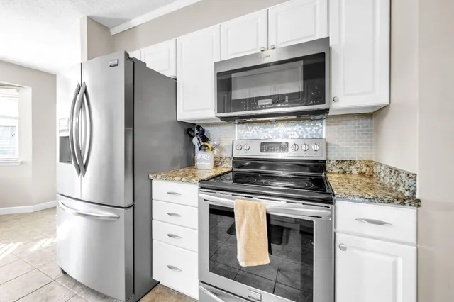 a kitchen with granite countertop a sink and cabinets