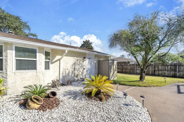 a white house with a big yard and large trees