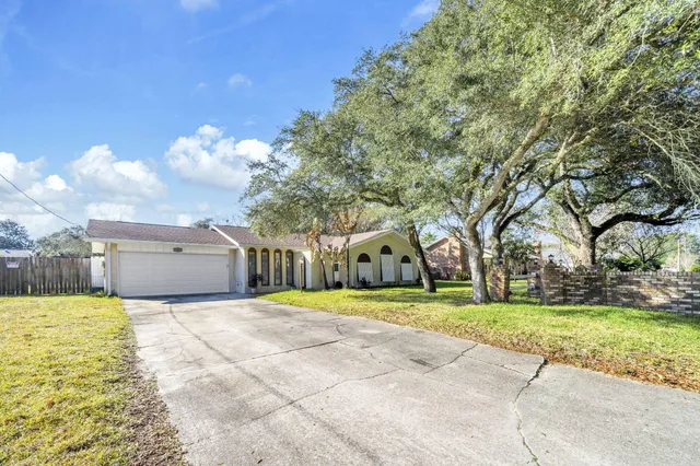 a view of a backyard with brick wall and potted plants
