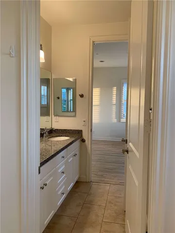 a bathroom with a granite countertop sink mirror and vanity