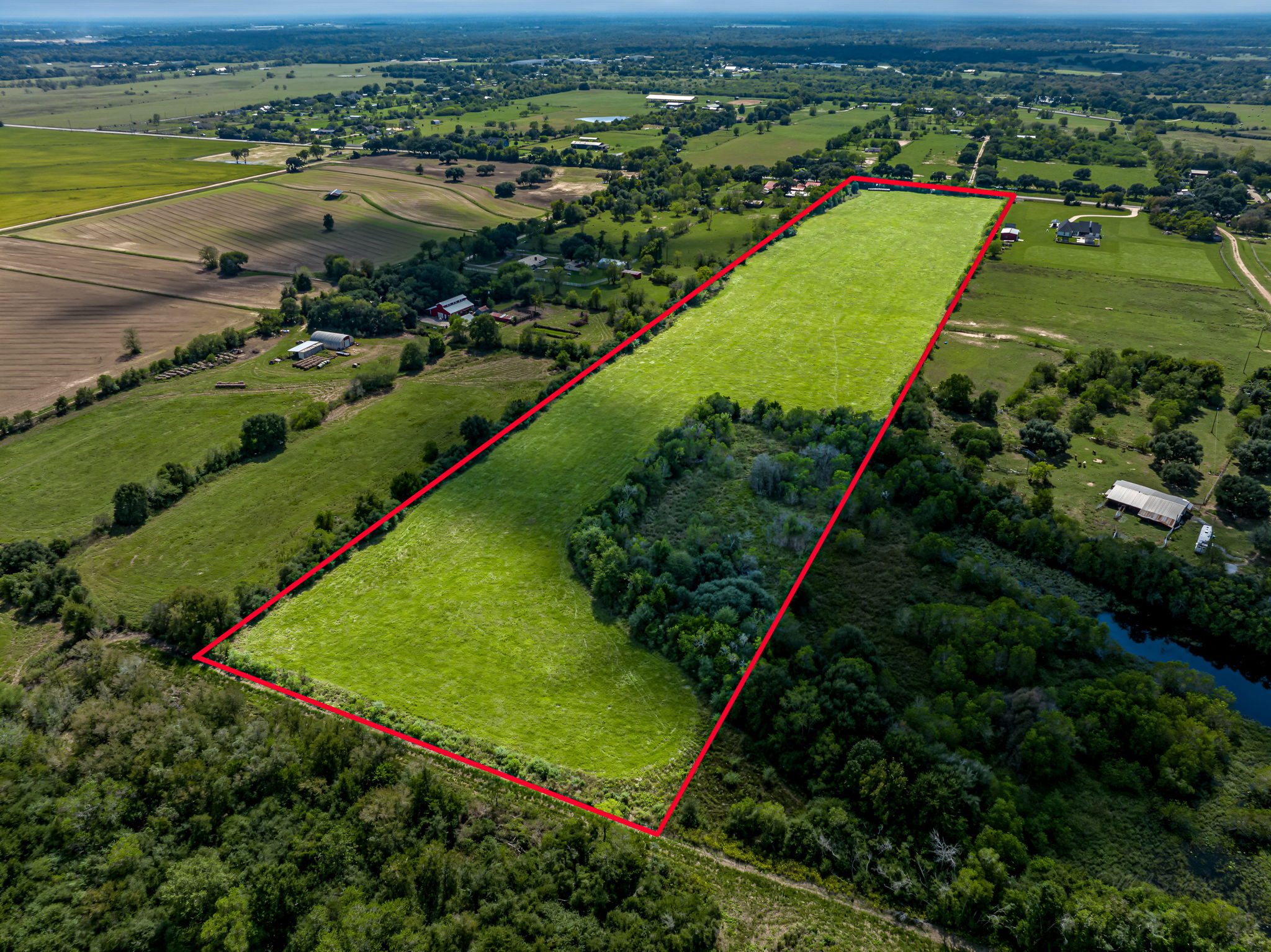 37280 Clapp Road Brookshire, TX 77423 - Photo 15 of 34 Lush green pastures and mature trees define this expansive rural property landscape.