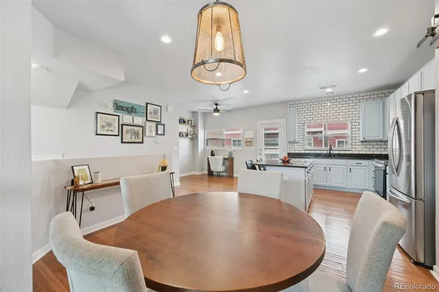 a large kitchen with a table chairs refrigerator and microwave