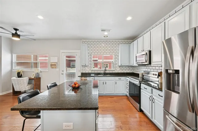 a kitchen with stainless steel appliances granite countertop a stove refrigerator sink and cabinets