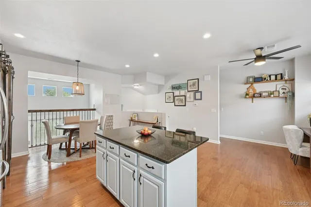 a open kitchen with stainless steel appliances granite countertop a stove and a wooden floors