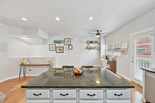 a view of kitchen island with stainless steel appliances granite countertop a sink and cabinets