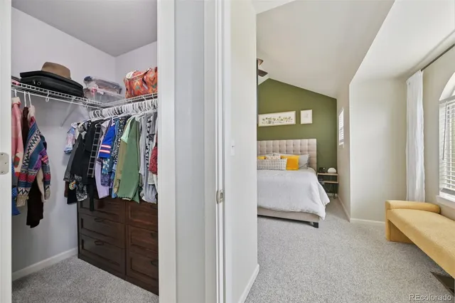 a view of walk in closet with clothes and shoes