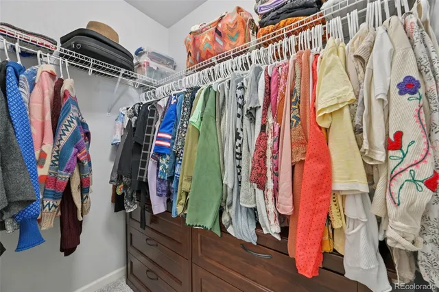 a view of walk in closet with clothes