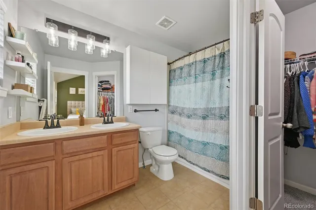 a bathroom with a double vanity sink toilet and shower
