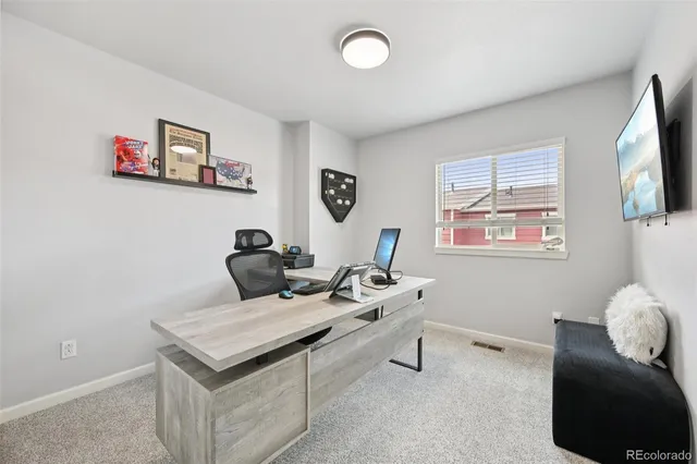 a view of a workspace with furniture and a window