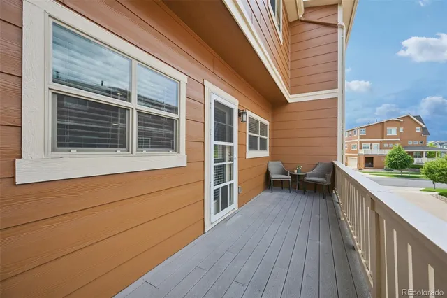 a view of a house with a barbeque and wooden stairs