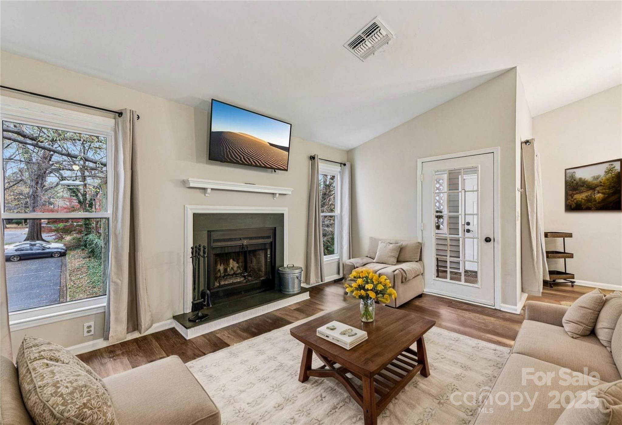 430 Queens Road, Unit 732 Charlotte, NC 28204 - Photo 4 of 17 a living room with furniture a flat screen tv and a fireplace