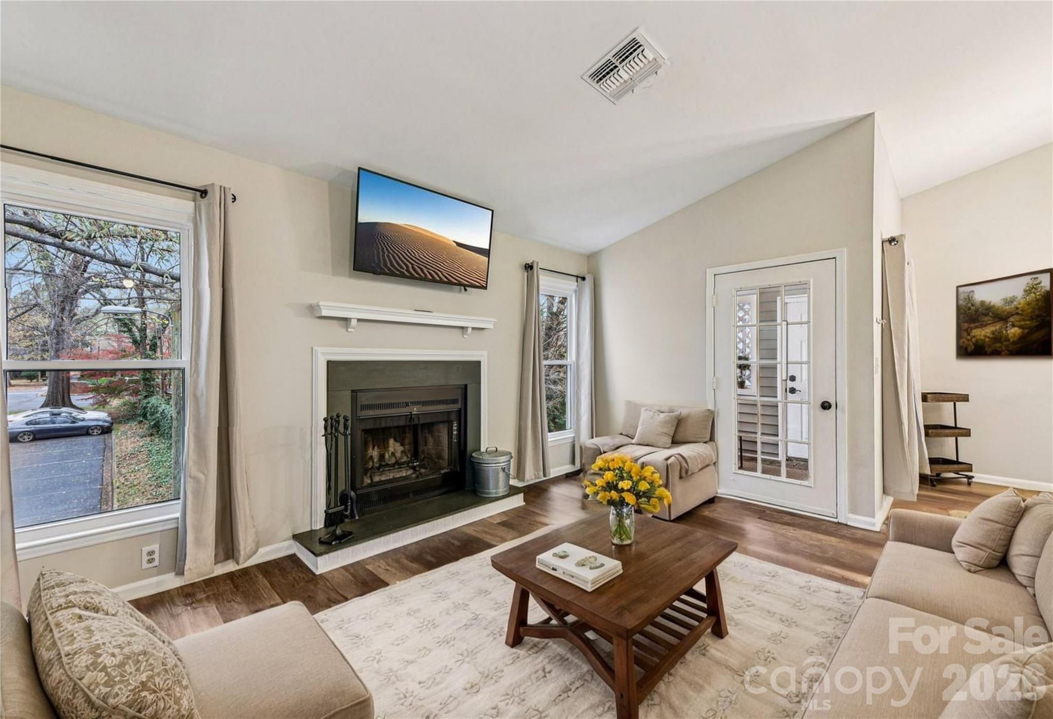 430 Queens Road, Unit 732 Charlotte, NC 28204 - Photo 5 of 17 a living room with furniture a flat screen tv and a fireplace