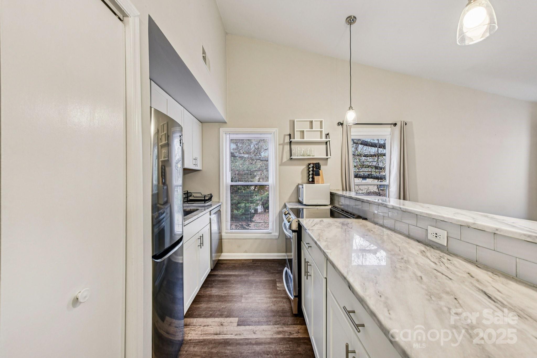 430 Queens Road, Unit 732 Charlotte, NC 28204 - Photo 8 of 17 a kitchen with stainless steel appliances granite countertop a sink stove and refrigerator
