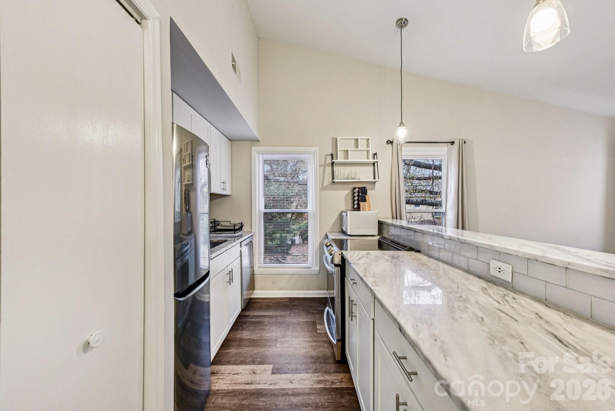 430 Queens Road, Unit 732 Charlotte, NC 28204 - Photo 8 of 17 a kitchen with stainless steel appliances granite countertop a sink stove and refrigerator