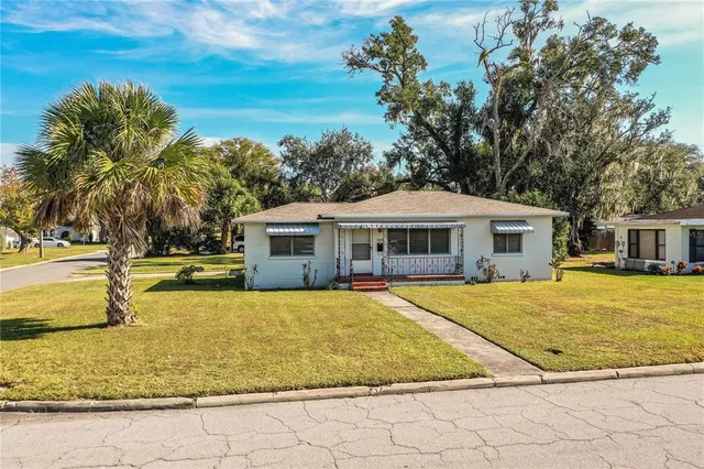 a view of a house with swimming pool and trees in the background