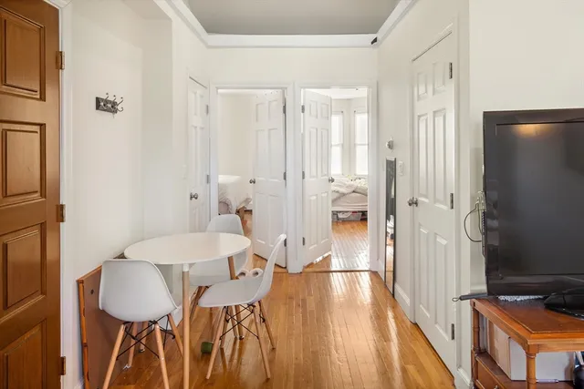 a view of a hallway with furniture and wooden floor