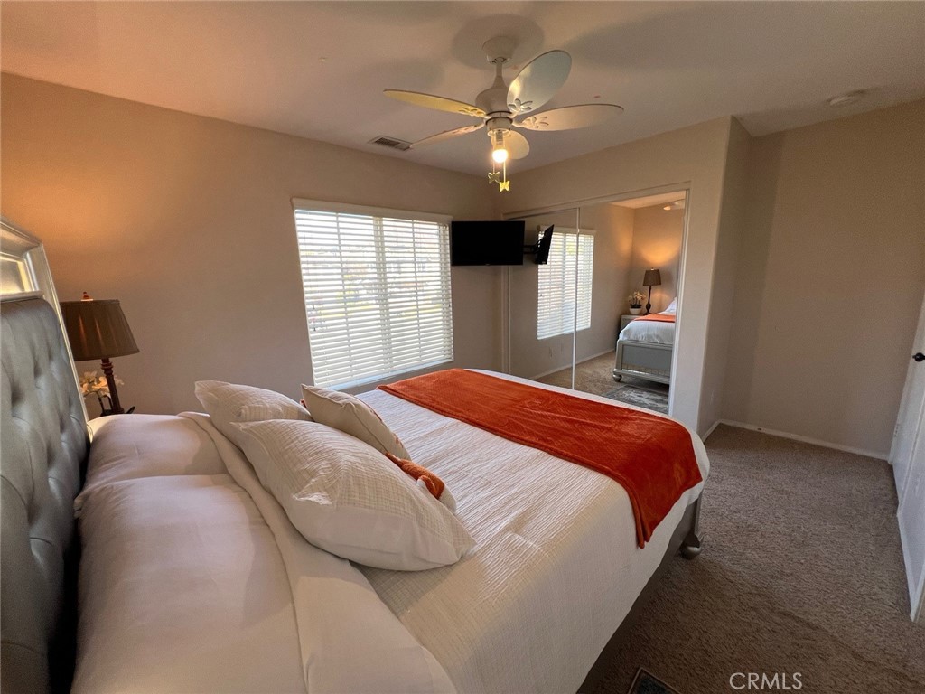 11617 Harvard Way Yucaipa, CA 92399 - Photo 48 of 58 a bedroom with a large bed and a chandelier