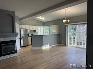 a view of a kitchen with a stove wooden cabinets and wooden floor