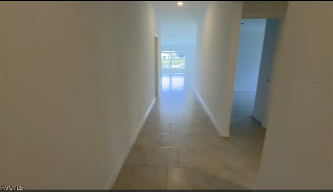 12312 Amber Waves Road Lehigh Acres, FL 33974 - Photo 6 of 33 a hallway with wooden floor in front of door