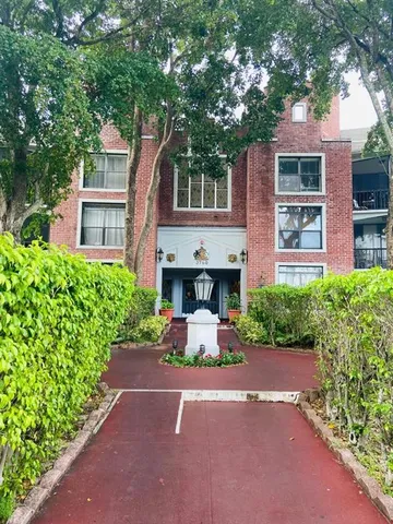 front view of a house with a garden and an trees