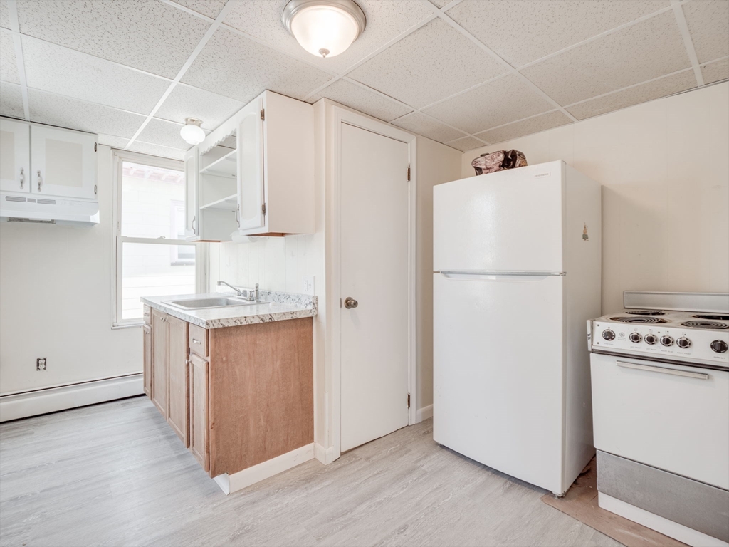 a kitchen with refrigerator a stove a microwave and white cabinets