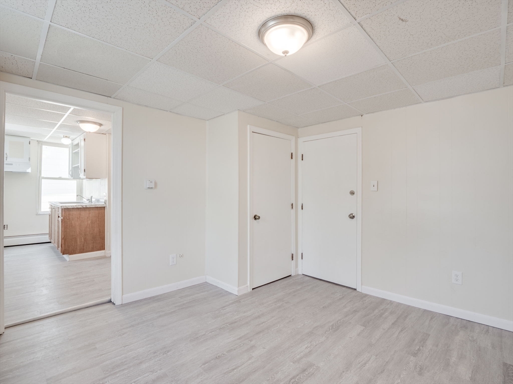 23 Lowell Street, Unit 2R Methuen, MA 01844 - Photo 3 of 5 an empty room with wooden floor and windows