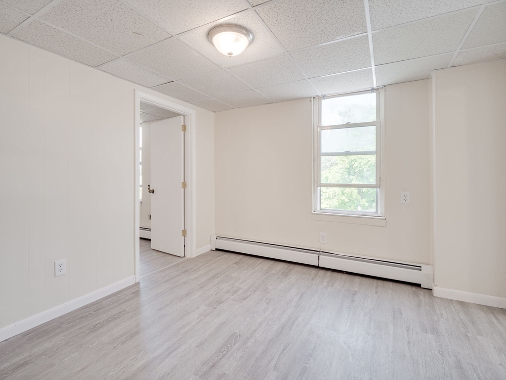 23 Lowell Street, Unit 2R Methuen, MA 01844 - Photo 4 of 5 an empty room with wooden floor and windows