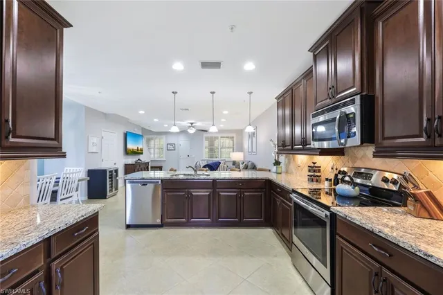 a kitchen with granite countertop stainless steel appliances and wooden cabinets