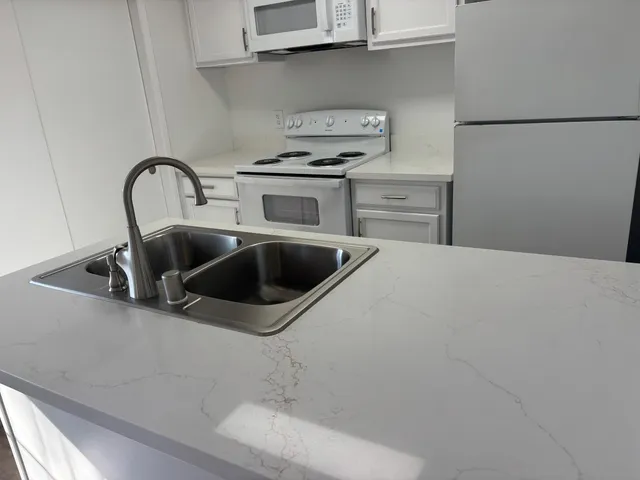 a close view of a sink a faucet and appliance in the kitchen