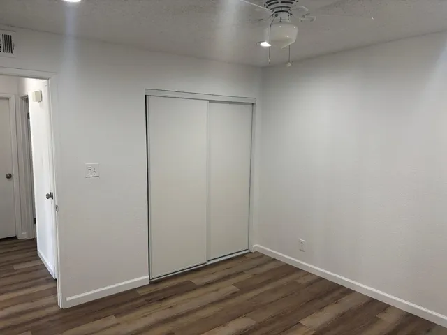 a view of an empty room with wooden floor