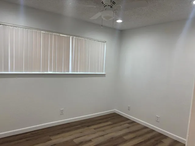 a view of an empty room with wooden floor
