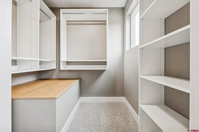 a view of walk in closet with empty racks