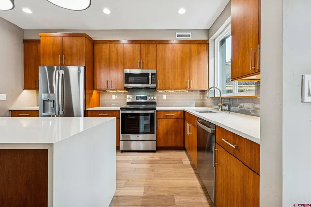 a kitchen with stainless steel appliances a stove sink and refrigerator