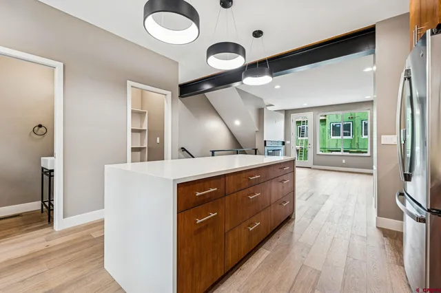 a kitchen with a wooden floor and a large window