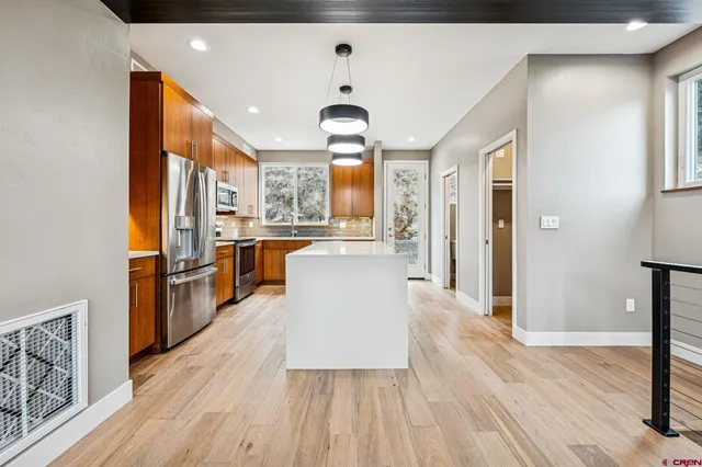 a large kitchen with stainless steel appliances granite countertop a stove and a refrigerator