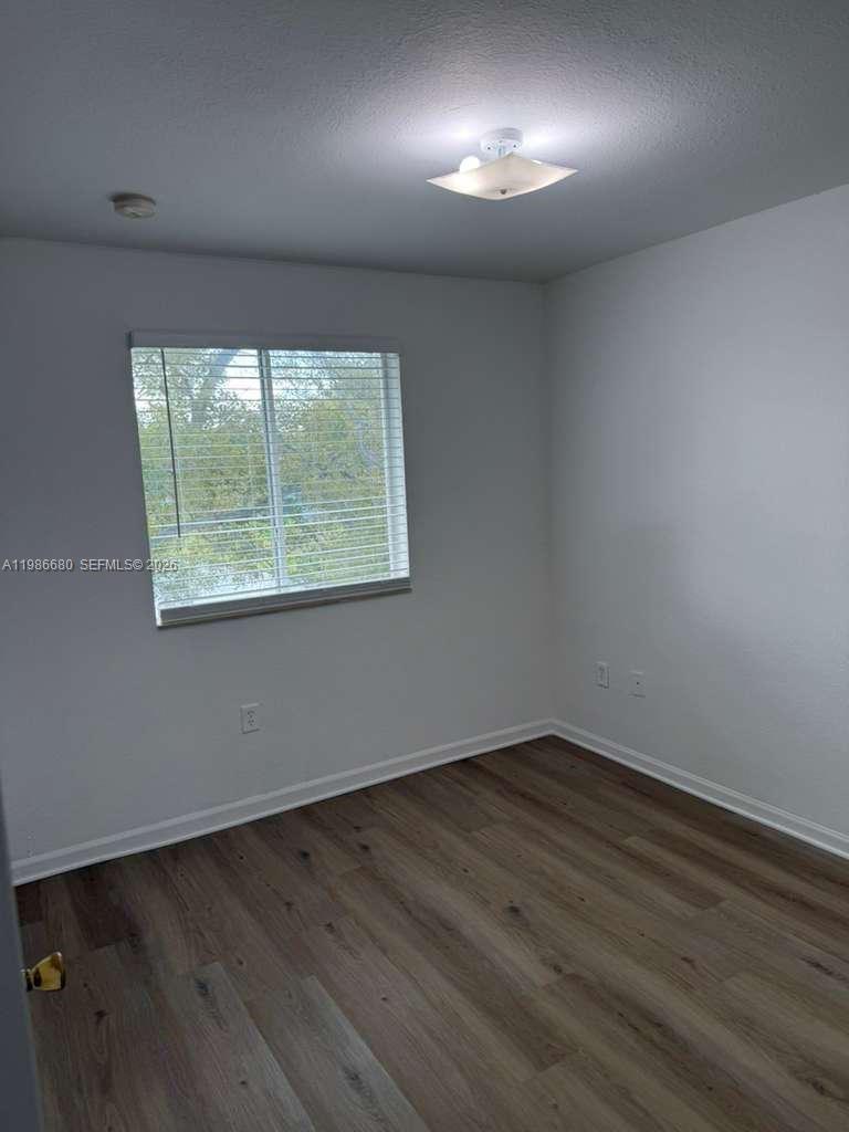 2470 Southeast 15th Place, Unit 335 Homestead, FL 33035 - Photo 11 of 33 an empty room with wooden floor and windows