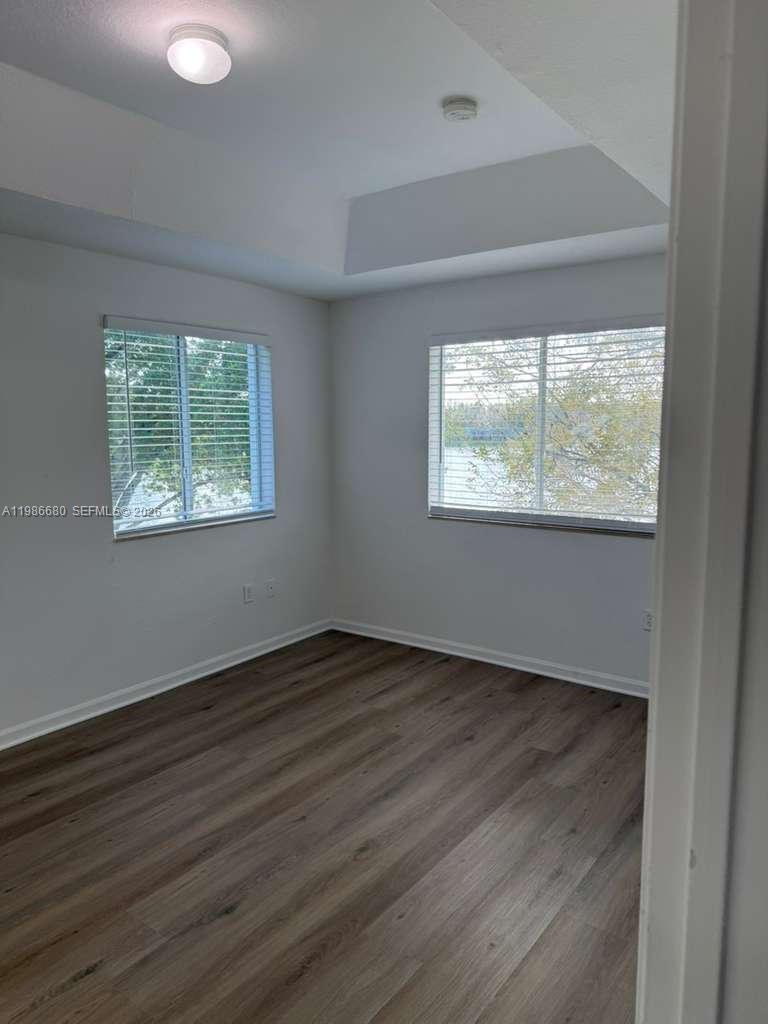 2470 Southeast 15th Place, Unit 335 Homestead, FL 33035 - Photo 14 of 33 an empty room with wooden floor and windows