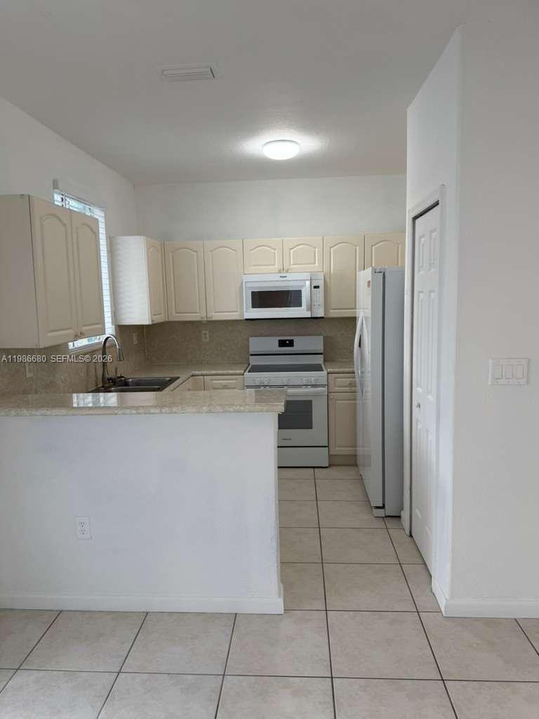 2470 Southeast 15th Place, Unit 335 Homestead, FL 33035 - Photo 2 of 33 a kitchen with stainless steel appliances granite countertop a refrigerator and a stove