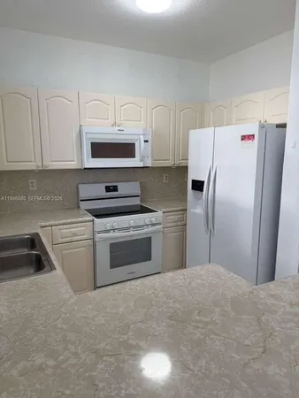a kitchen with a refrigerator sink and cabinets