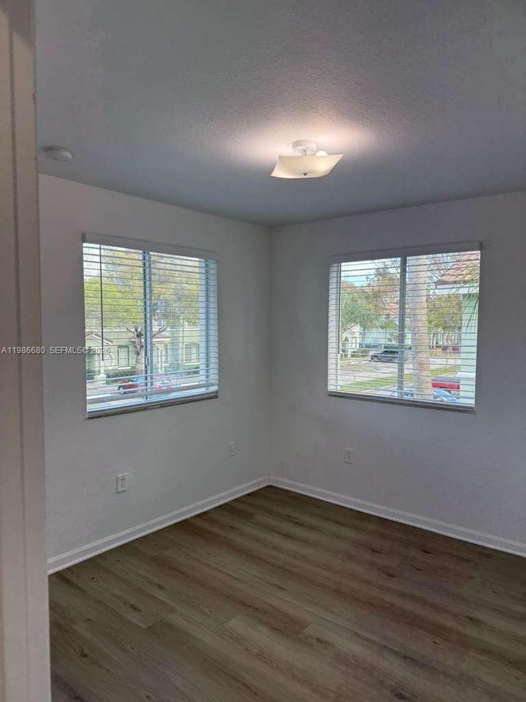 2470 Southeast 15th Place, Unit 335 Homestead, FL 33035 - Photo 6 of 33 a view of an empty room with wooden floor and a window