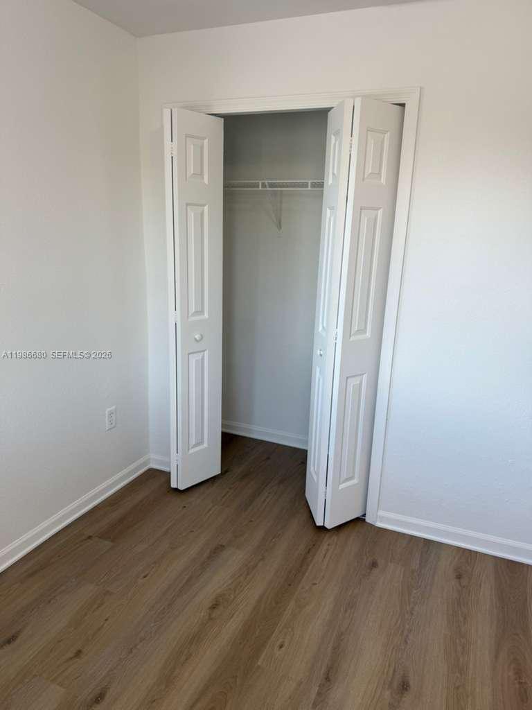 2470 Southeast 15th Place, Unit 335 Homestead, FL 33035 - Photo 7 of 33 an empty room with wooden floor and closet