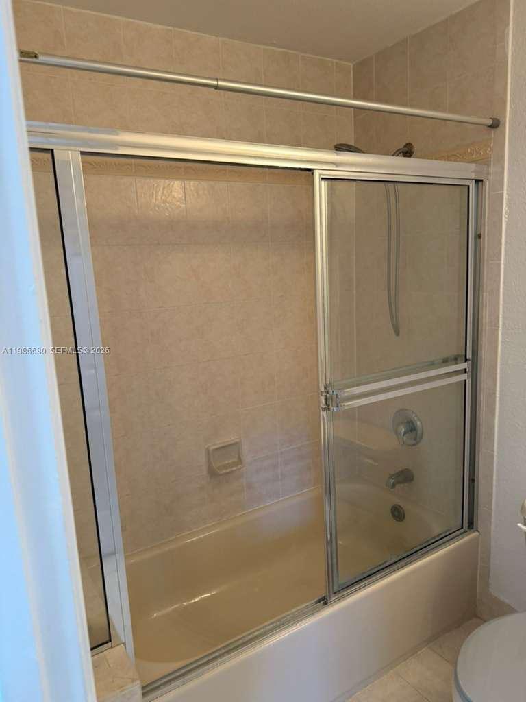 2470 Southeast 15th Place, Unit 335 Homestead, FL 33035 - Photo 9 of 33 a bathroom with a glass shower door