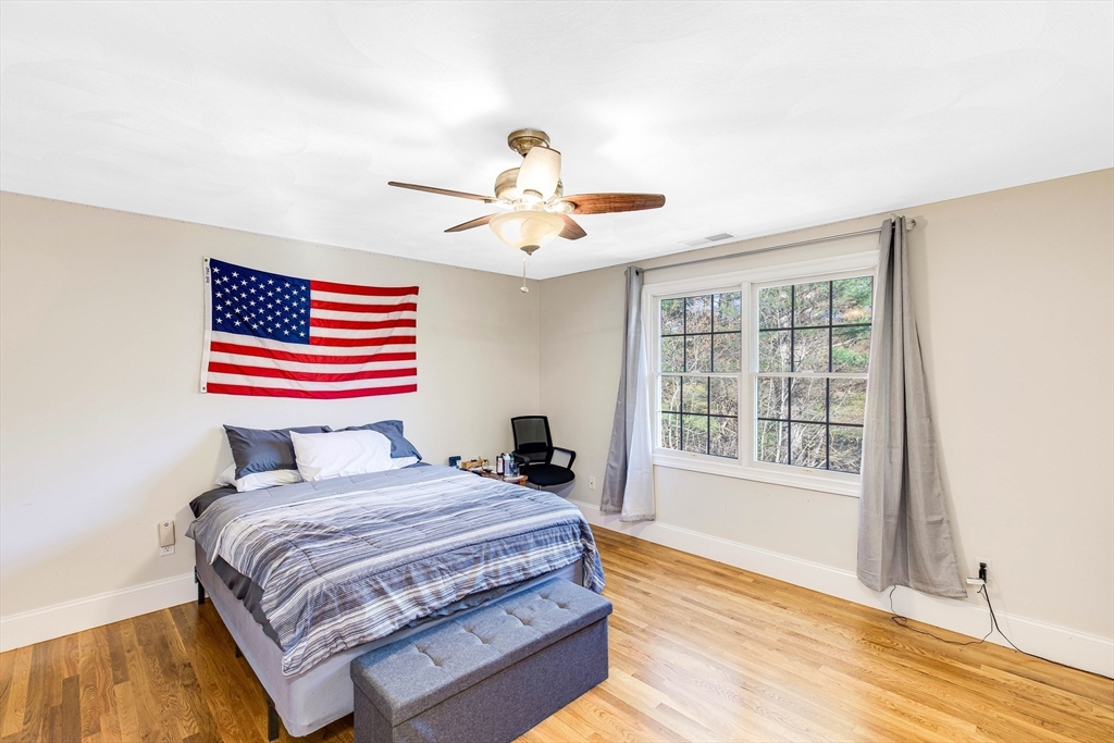 53 Emily Lane Rowley, MA 01969 - Photo 20 of 42 a bedroom with a bed and a chandelier