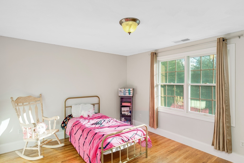 53 Emily Lane Rowley, MA 01969 - Photo 21 of 42 a bedroom with a bed and wooden floor