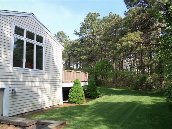 34 Monomoscoy Road Mashpee, MA 02649 - Photo 3 of 16 a view of a backyard with plants and large trees