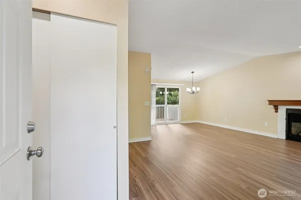 a view of a hallway with wooden floor and a bathroom