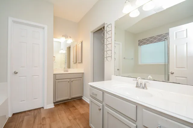 a bathroom with a granite countertop bathtub shower sink vanity mirror and toilet