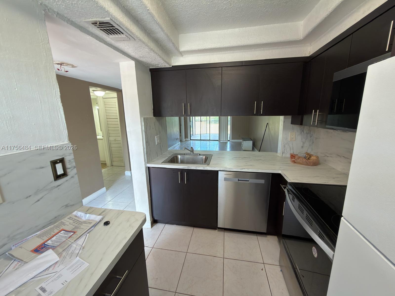 3400 Foxcroft Road, Unit 212 Miramar, FL 33025 - Photo 1 of 22 a kitchen with a sink a stove and cabinets