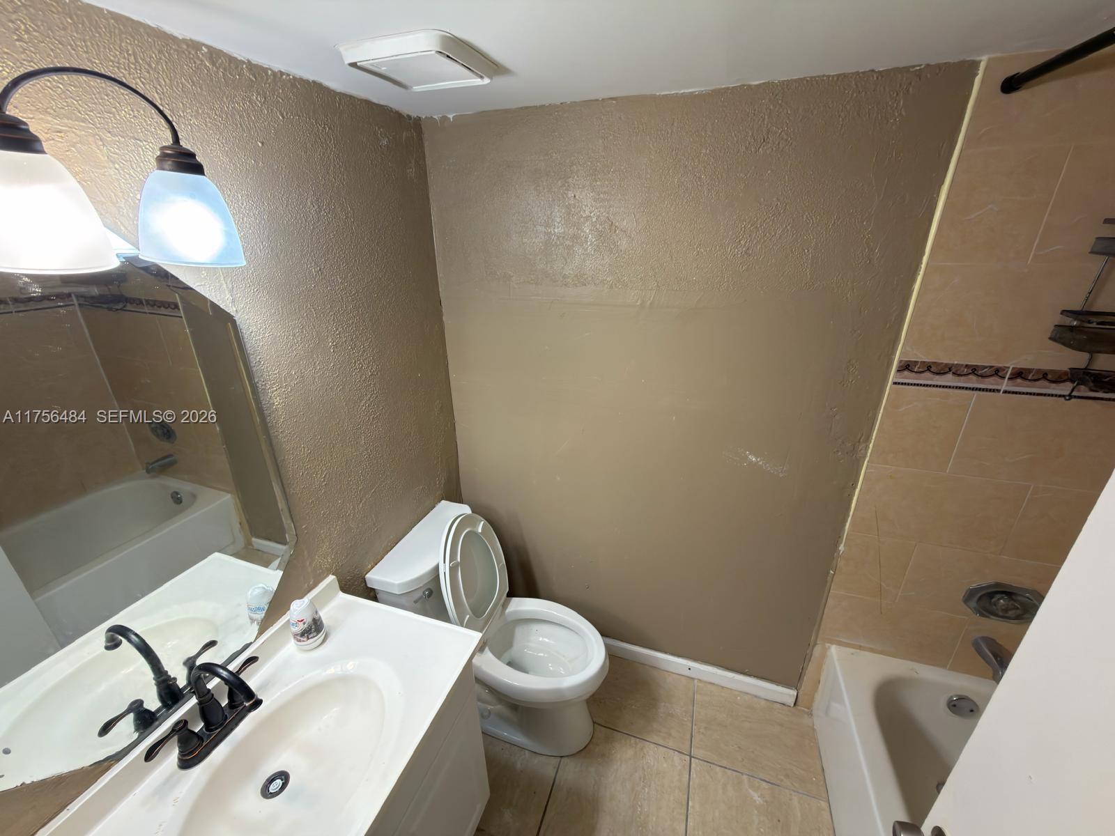 3400 Foxcroft Road, Unit 212 Miramar, FL 33025 - Photo 11 of 22 a white toilet sitting next to a bathroom sink